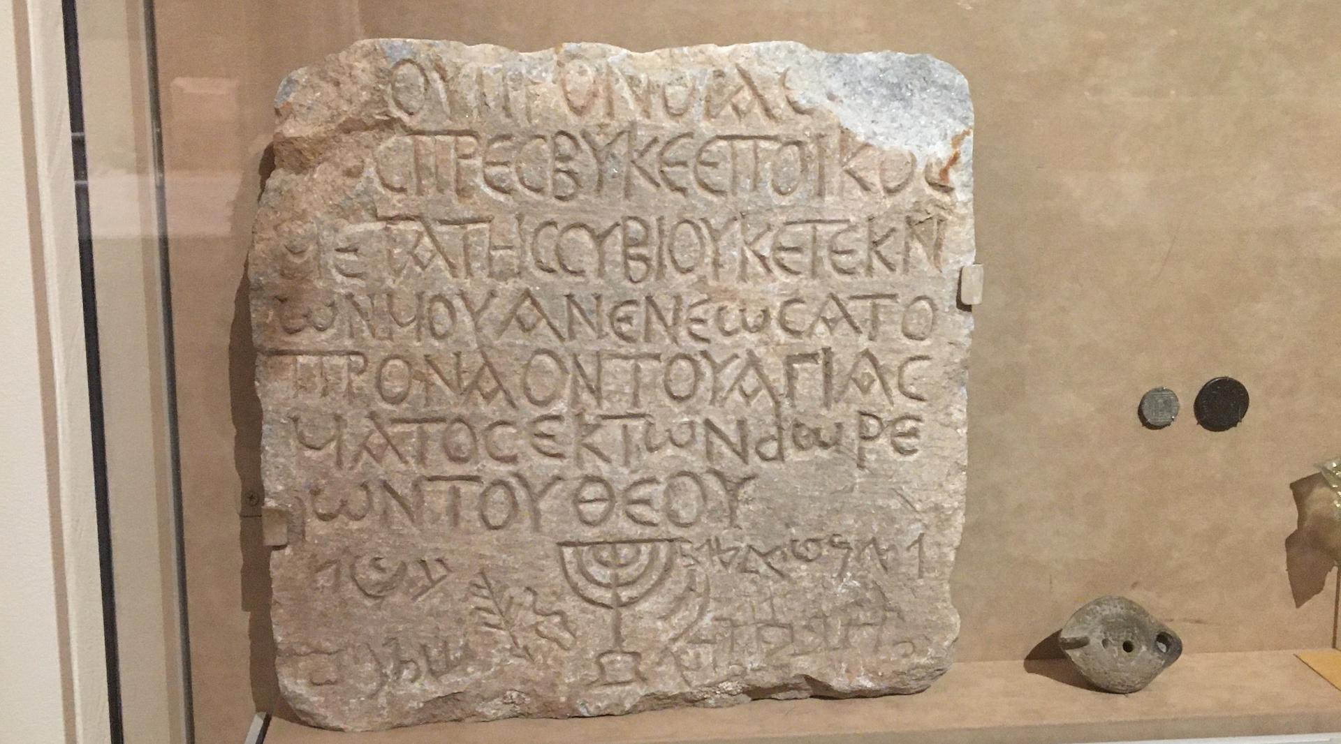 A marble plaque recording a donation to a Roman synagogue is in The Metropolitan Museum of Art, next to the staircase which is lined with the the names of the people who gave donations to the museum. (Jewish Week)