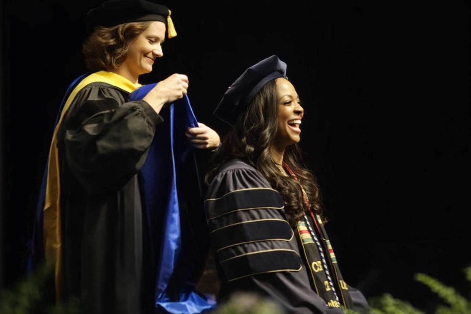 Misty Thomas placing hood on Dr. Brittany Sanders